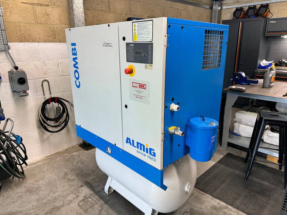 Large blue and white industrial compressor in a workshop setting