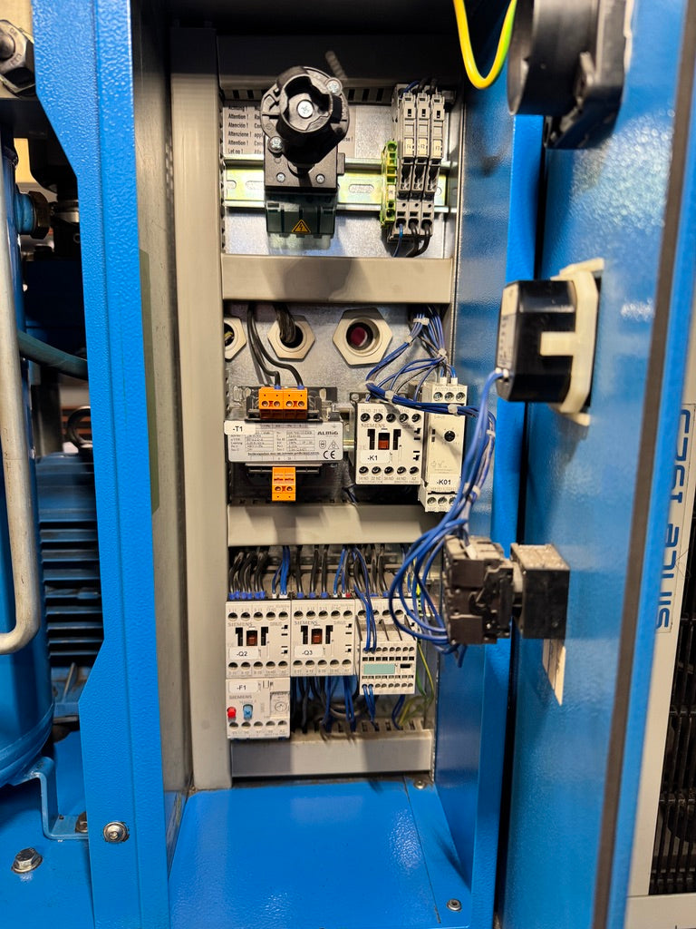 Close-up of an industrial control panel with various components and wiring.