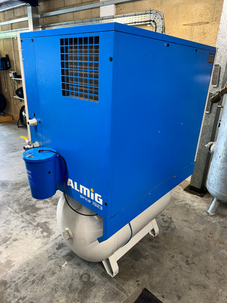 Blue industrial machine with 'Almig' branding on a concrete floor.