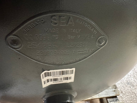 Metal component with 'SEA' branding and a barcode label on a blurred background