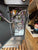 Open electronic cabinet with visible wiring and components on a wooden floor.