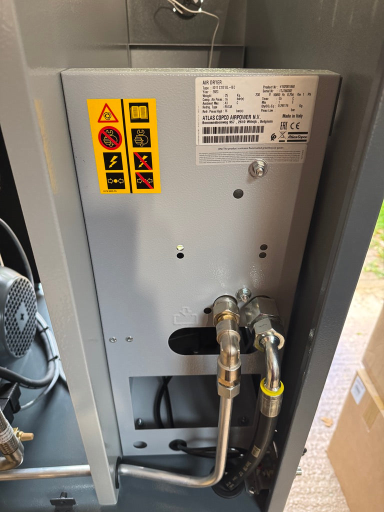 Back panel of a machine with warning labels and hoses
