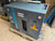 Atlas Copco air compressor on a wooden pallet with a concrete floor background
