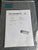 Test certificate and small device inside a clear plastic bag with Atlas Copco branding.