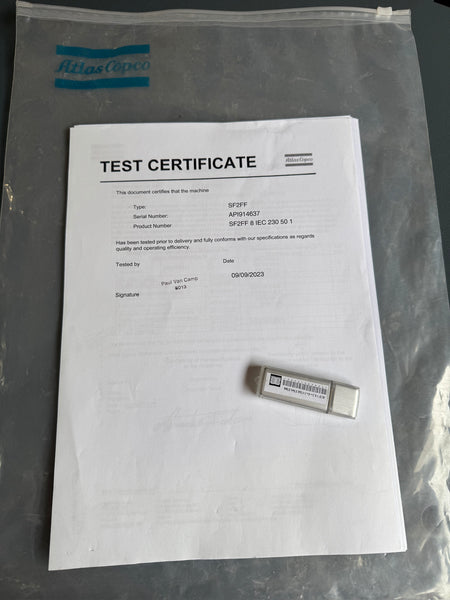 Test certificate and small device inside a clear plastic bag with Atlas Copco branding.