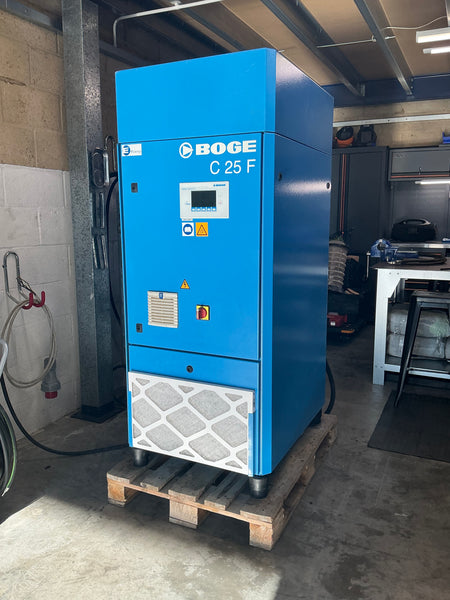 A blue BOGE C 25 F industrial air compressor sitting on a wooden pallet in a workshop environment.
