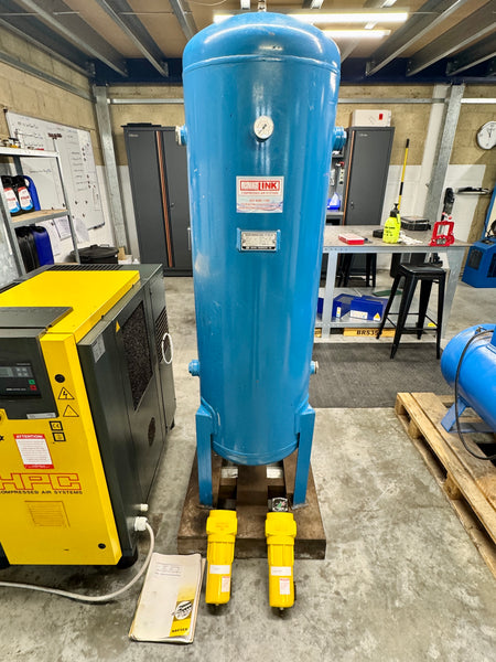 Blue cylindrical tank with yellow feet in a workshop setting