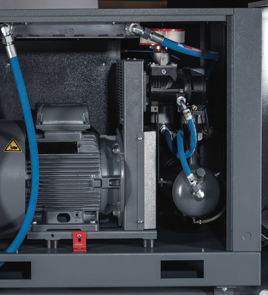 Close-up of an industrial air compressor with visible components and hoses.