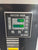 Close-up of an industrial electronic control panel labeled ES 3000, showing a digital display with green numerals and multiple button controls on a dark metal face.