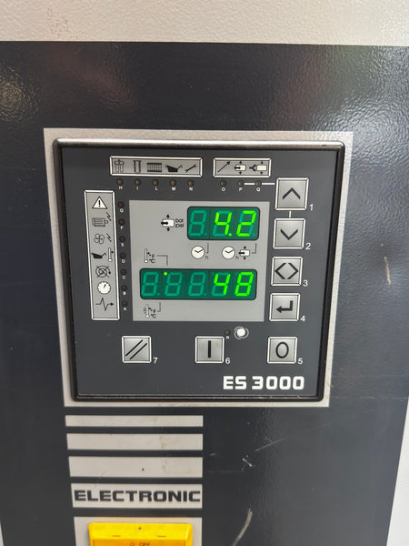 Close-up of an industrial electronic control panel labeled ES 3000, showing a digital display with green numerals and multiple button controls on a dark metal face.