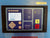 A BOGE industrial touchscreen control panel mounted on a blue metal surface. The panel has a dark frame and a purple faceplate with beige buttons, a white display screen, and red and yellow function buttons.