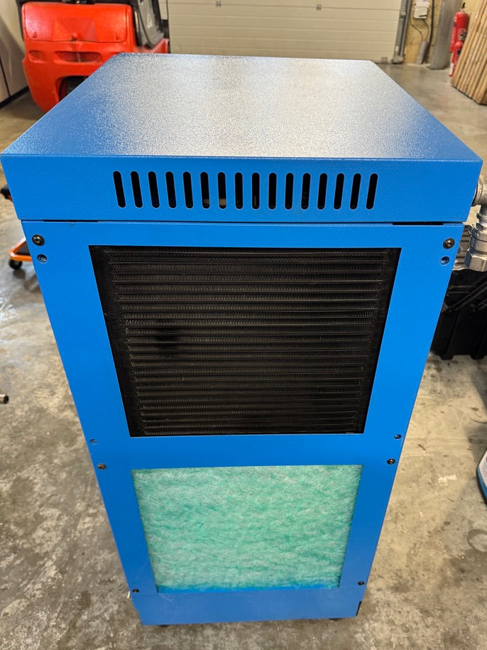 Blue air compressor unit with black grille on a concrete floor