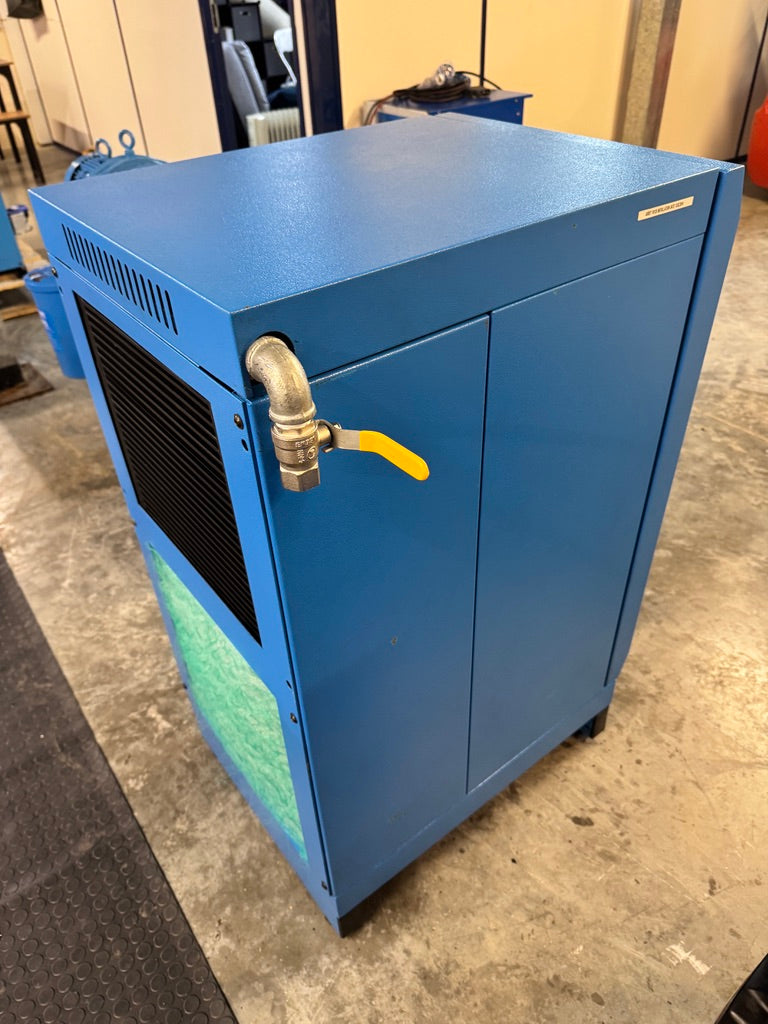 Blue industrial machine with a yellow valve on a concrete floor