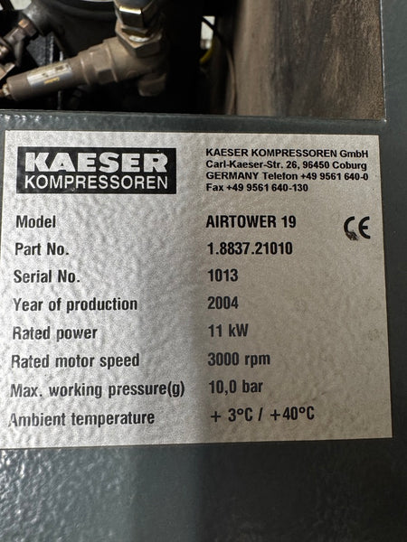 A close-up of a metal nameplate on industrial machinery showing the brand KAESER KOMPRESSOREN and model AIRTOWER 19 with technical specifications.