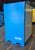 Blue storage container with 'Almac' branding on a warehouse floor.