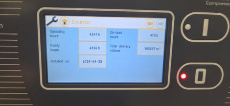 Display screen of a machine showing operational hours and other metrics.